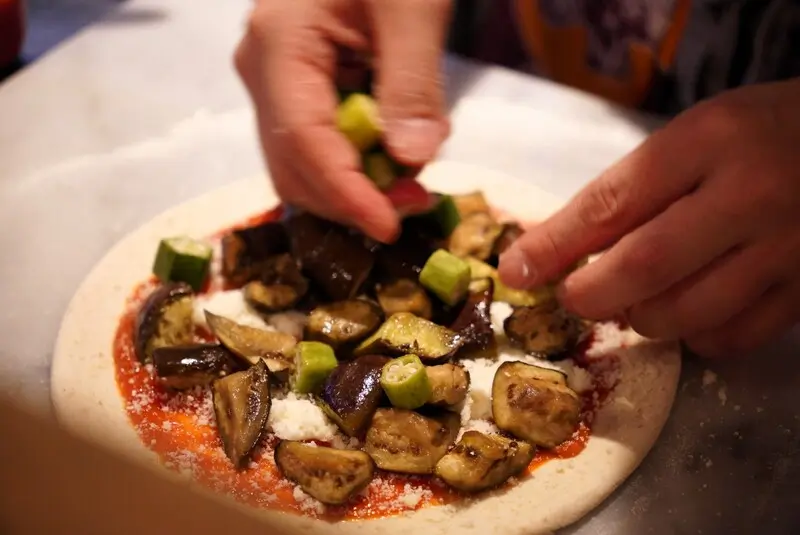 鎌田製作所　ピザに具材をのせている様子